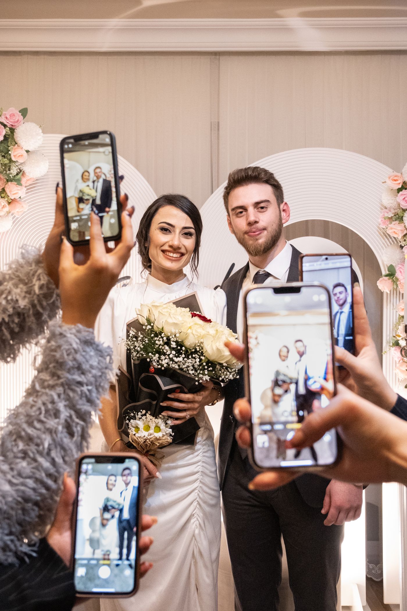 Guests holding up their phones to photograph the newlyweds after the ceremony.